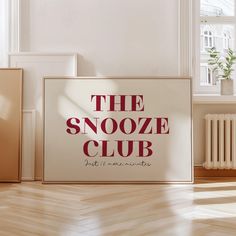 the snooze club sign in front of an empty room with wooden floors