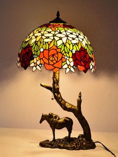 a table lamp with a horse on it and a flowered shade over the base