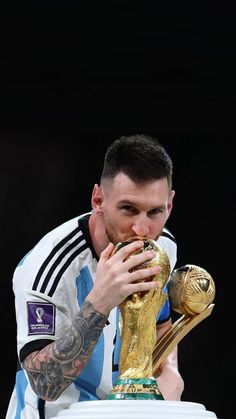 a man holding a soccer trophy in his hands