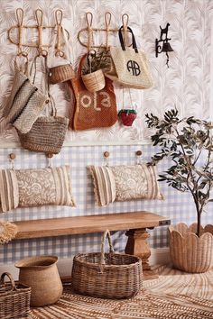 a bench and some baskets hanging on the wall