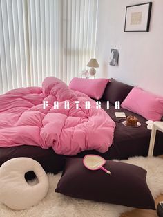 there is a bed with pink sheets and pillows on top of it, next to a window