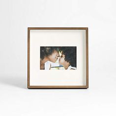 an image of two people kissing in front of a white background with a brown frame