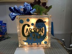 a glass block with a dinosaur on it that says carbon james and is lit up