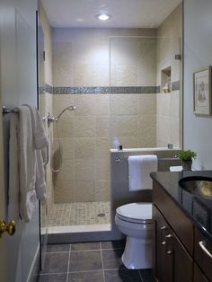 a bathroom with a walk in shower next to a toilet