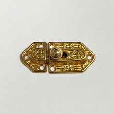 an antique brass plated door handle on a white surface with holes in the middle