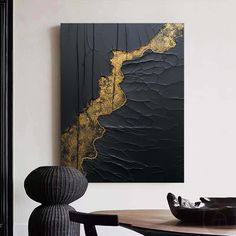 a black and gold painting on the wall in a dining room