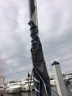 the sailboat is docked at the dock with other boats in the water behind it