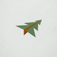 an origami airplane flying in the sky with a trail coming out of it