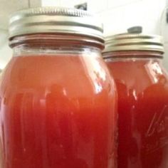 two jars filled with liquid sitting on top of a counter