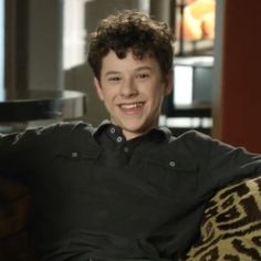 a young man sitting on top of a couch