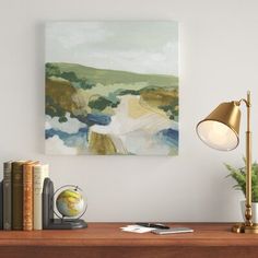 a painting on the wall above a desk with a lamp and other office supplies next to it