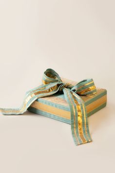 a gift wrapped in blue and gold ribbon