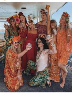 a group of women standing next to each other on a boat holding drinks in their hands