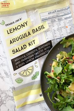 a plate of salad sitting next to a packet of lemony arugula basil