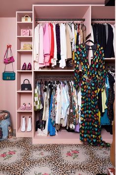 an organized closet with clothes and handbags hanging on shelves, including shoes and purses