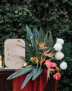 an arrangement of flowers and greenery on a table