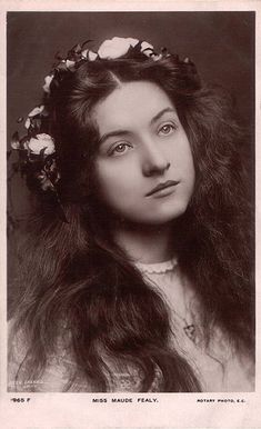 an old black and white photo of a woman with long hair wearing a flower crown