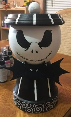 a halloween pumpkin with a hat on it's head and eyes painted black and white