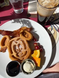 a white plate topped with food next to a cup of ice cream and orange wedges