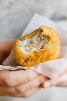 a person holding food in their hands with the words japanese croquets korokke above it