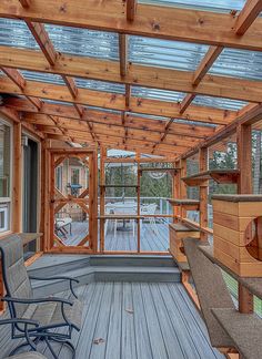 a screened porch with chairs and a hot tub in the middle, surrounded by wood planks