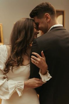 a man in a suit and tie hugging a woman