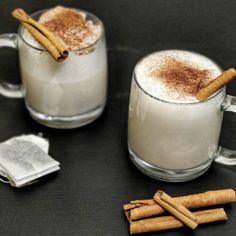 two mugs filled with cinnamon sitting on top of a table