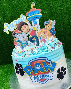 a birthday cake with paw patrol characters on top and sprinkles around the edges