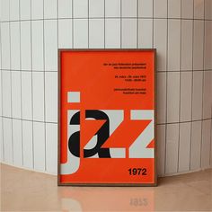 an orange and white poster on the wall next to a tiled floor in a bathroom