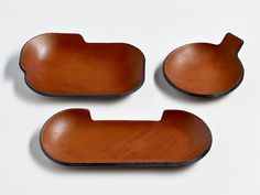 three pieces of brown leather sitting next to each other