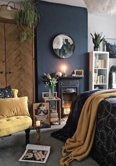 a bedroom decorated in blue and yellow with a bed, chair, fireplace and bookshelf