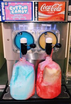 two soda dispensers sitting next to each other in front of a machine