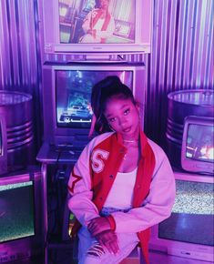 a woman sitting on top of a box in front of televisions