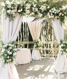 an outdoor wedding setup with white flowers and greenery