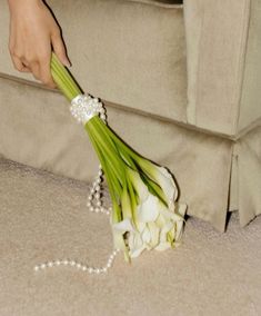 a woman is holding a bouquet of flowers on the floor