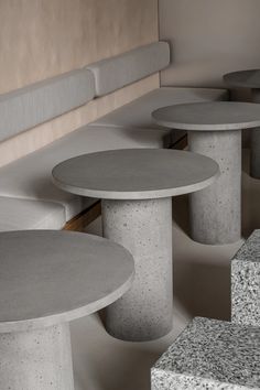 concrete tables and benches are lined up against the wall