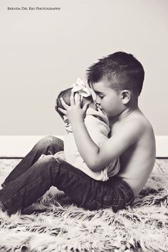 a young boy sitting on the floor holding a stuffed animal in his lap and saying, you're missing someone