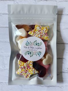 a bag filled with assorted candies on top of a white brick wall