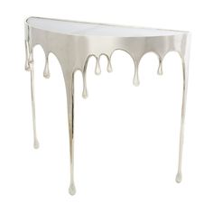 a white table with dripping paint on it's legs and bottom half covered in liquid