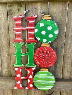 christmas ornaments hanging on the side of a wooden fence