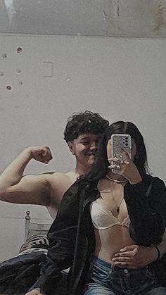 a man and woman taking a selfie in the mirror