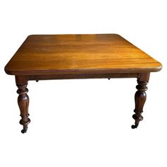 an old wooden table with turned legs and no one sitting at the top or standing up