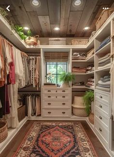 a walk in closet with lots of clothes and rugs on the floor next to it