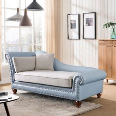 a blue chaise lounger sitting on top of a rug in a living room