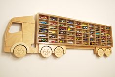 a wooden toy truck with lots of toys in it's storage bins on the wall