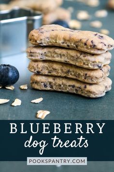 blueberry dog treats stacked on top of each other next to a cookie tin and fresh blueberries