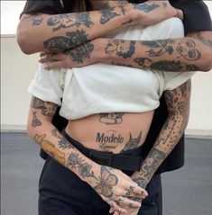 two people with tattoos hugging each other