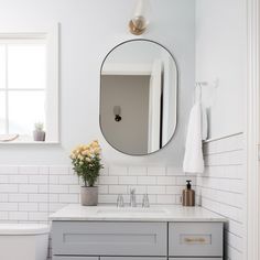 a bathroom with a sink, mirror and toilet in it's centerpieces