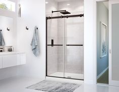 a bathroom with a glass shower door and rug on the floor