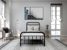 a bedroom with white walls and black iron bed frame in the middle, along with large windows